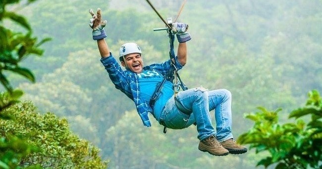 a man flying on a zipline at Sky Trek Arenal