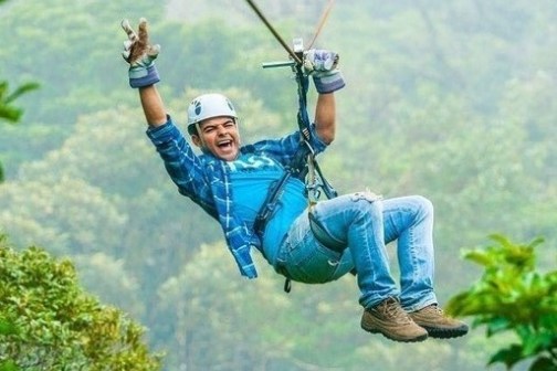 a man flying on a zipline at Sky Trek Arenal